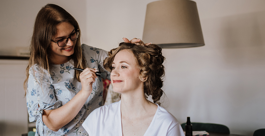 Braut wird von professioneller Visagistin geschminkt