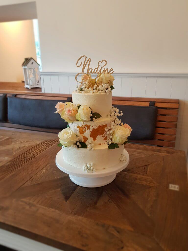 Hochzeistorte mit Blumendekoration und Cake-Topper