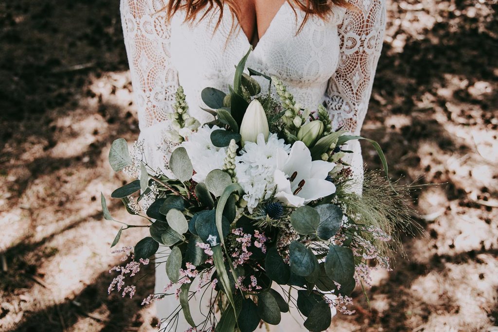 Passende Zusammenstellung eines Brautstrauß mit der richtigen Symbolik Weißer Blumenstrauss in den Händen der Braut