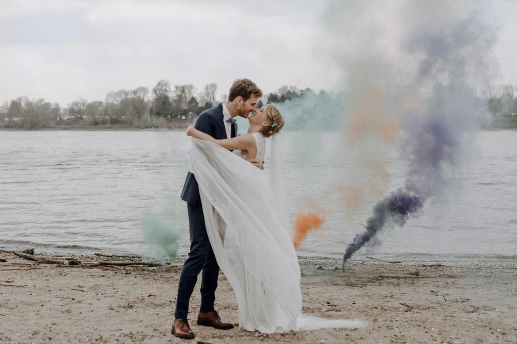 Kuss beim Paarshooting am See mit Rauchfeuerwerk Kuss eines Paares an einem See