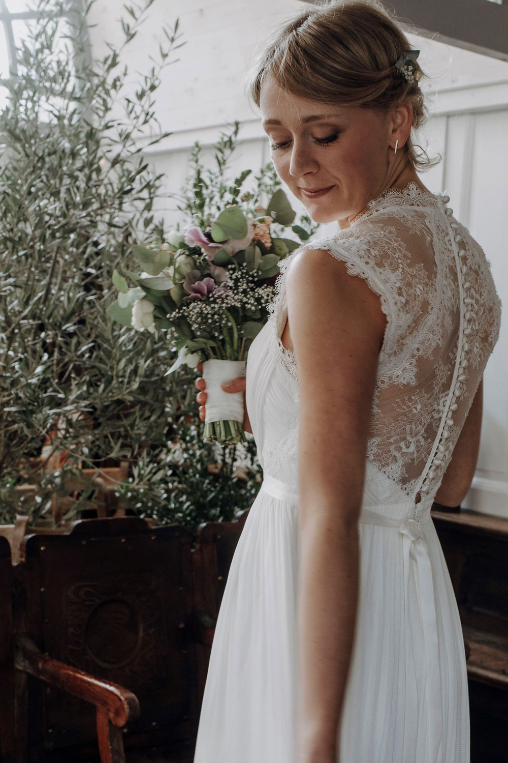 Braut vor Blumendekoration und mit Brautstrauß