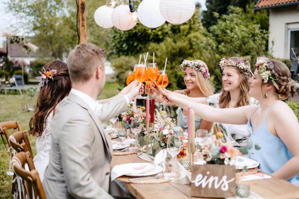 Brautpaar und Brautjungfern stoßen gemeinsam an Brautpaar und Brautjungfern stoßen gemeinsam an