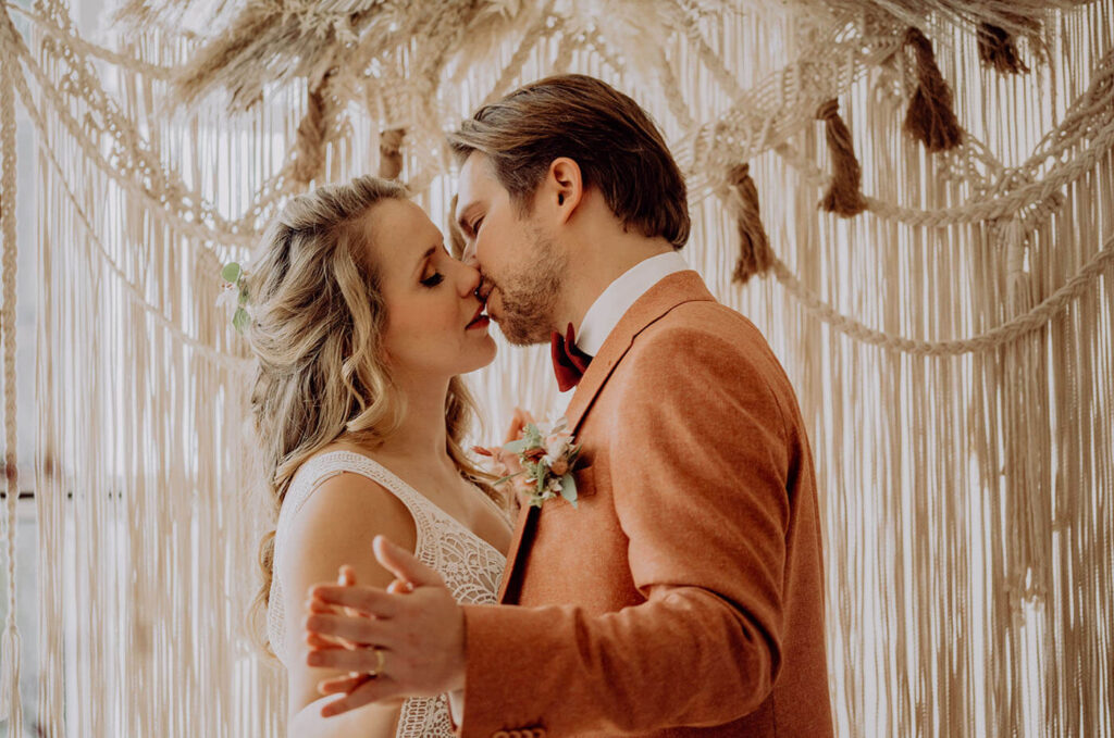 Hochzeitspaar küsst sich nach der Zeremonie Hochzeitspaar küsst sich nach der Zeremonie