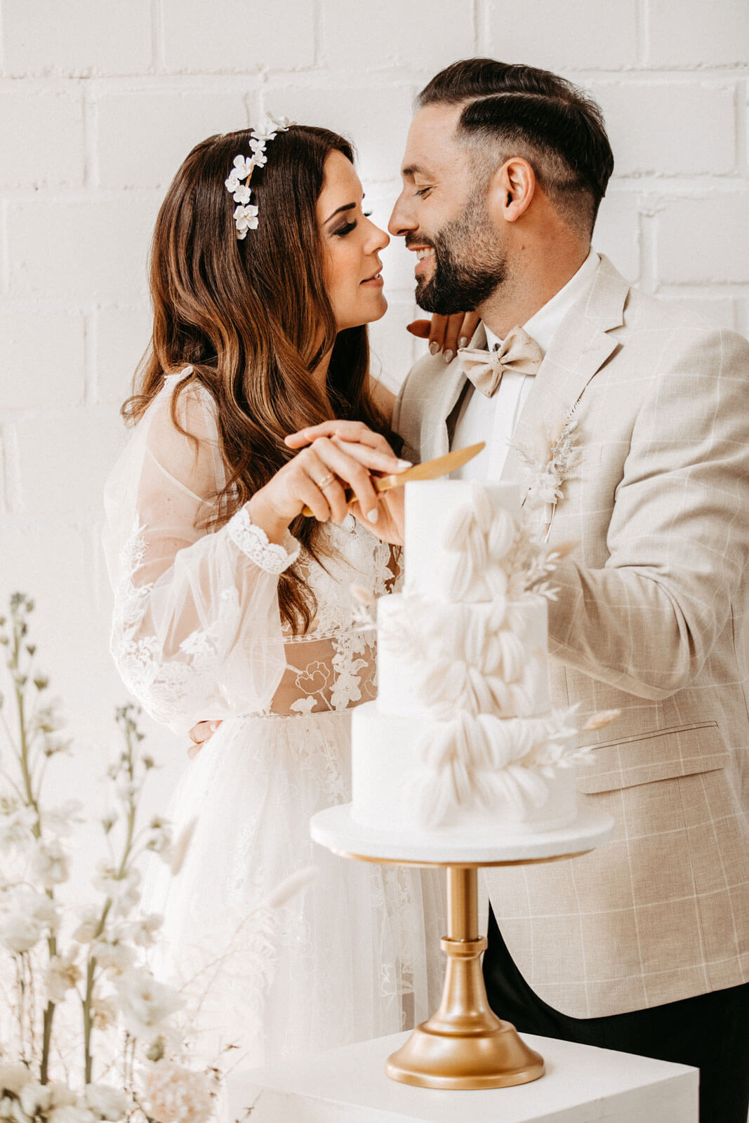 Hochzeitspaar schneidet gemeinsam die Hochzeitstorte an