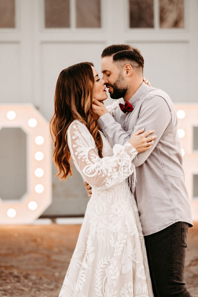 Brautpaar küsst sich vor LOVE Buchstaben Brautpaar küsst sich vor LOVE Buchstaben