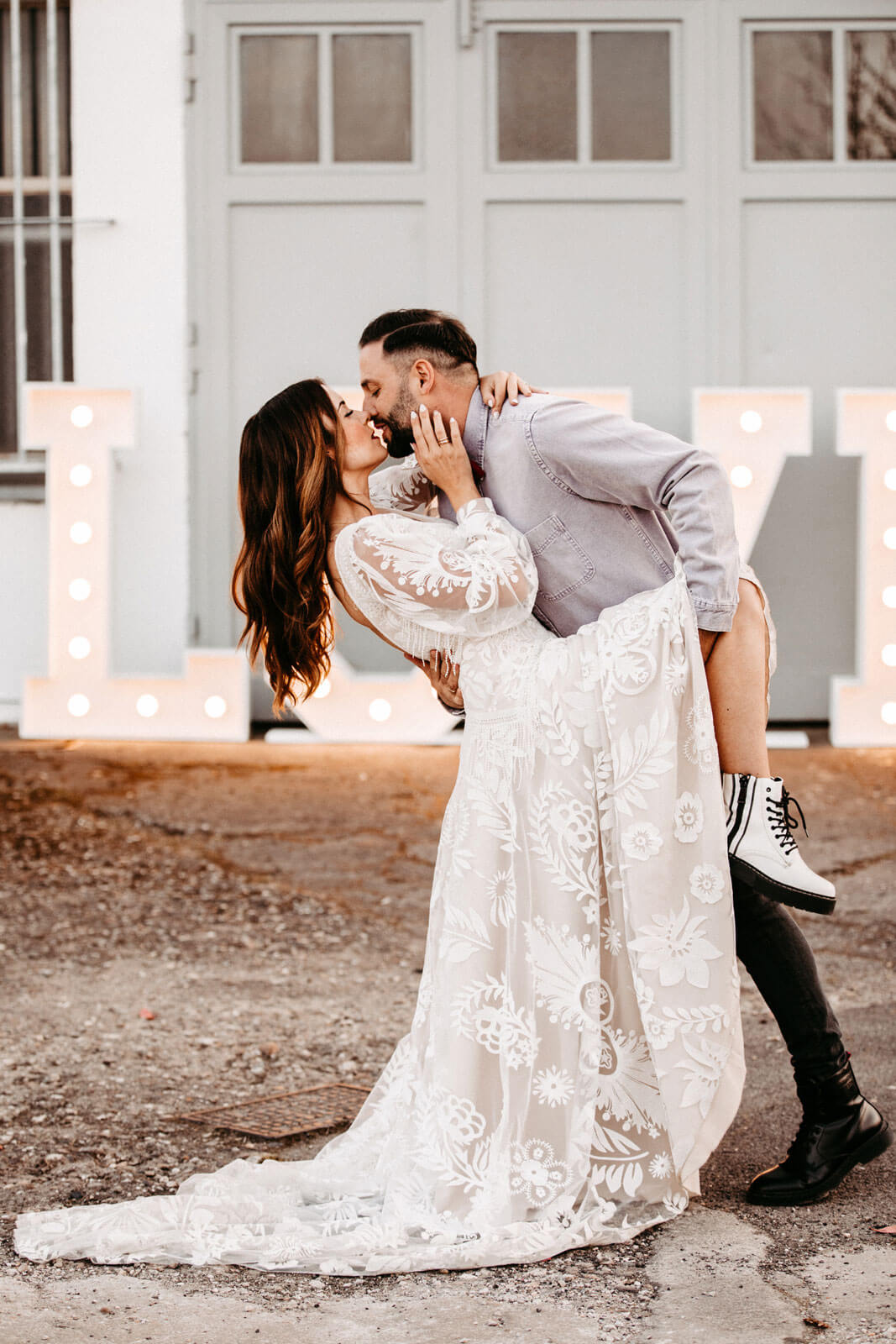 Brautpaar küsst sich vor LOVE Buchstaben