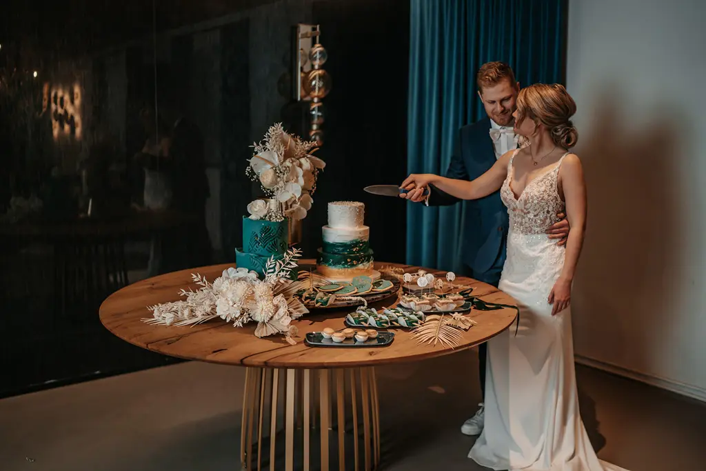 Brautpaar schneidet die Hochzeitstorte an