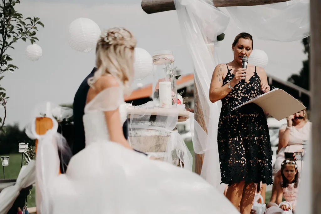 Traurednerin führt das Brautpaar durch die Zeremonie Traurednerin führt das Brautpaar durch die Zeremonie